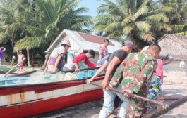 Babinsa Serda Muskhandar Bantu Tarik Perahu Nelayan Ke Darat